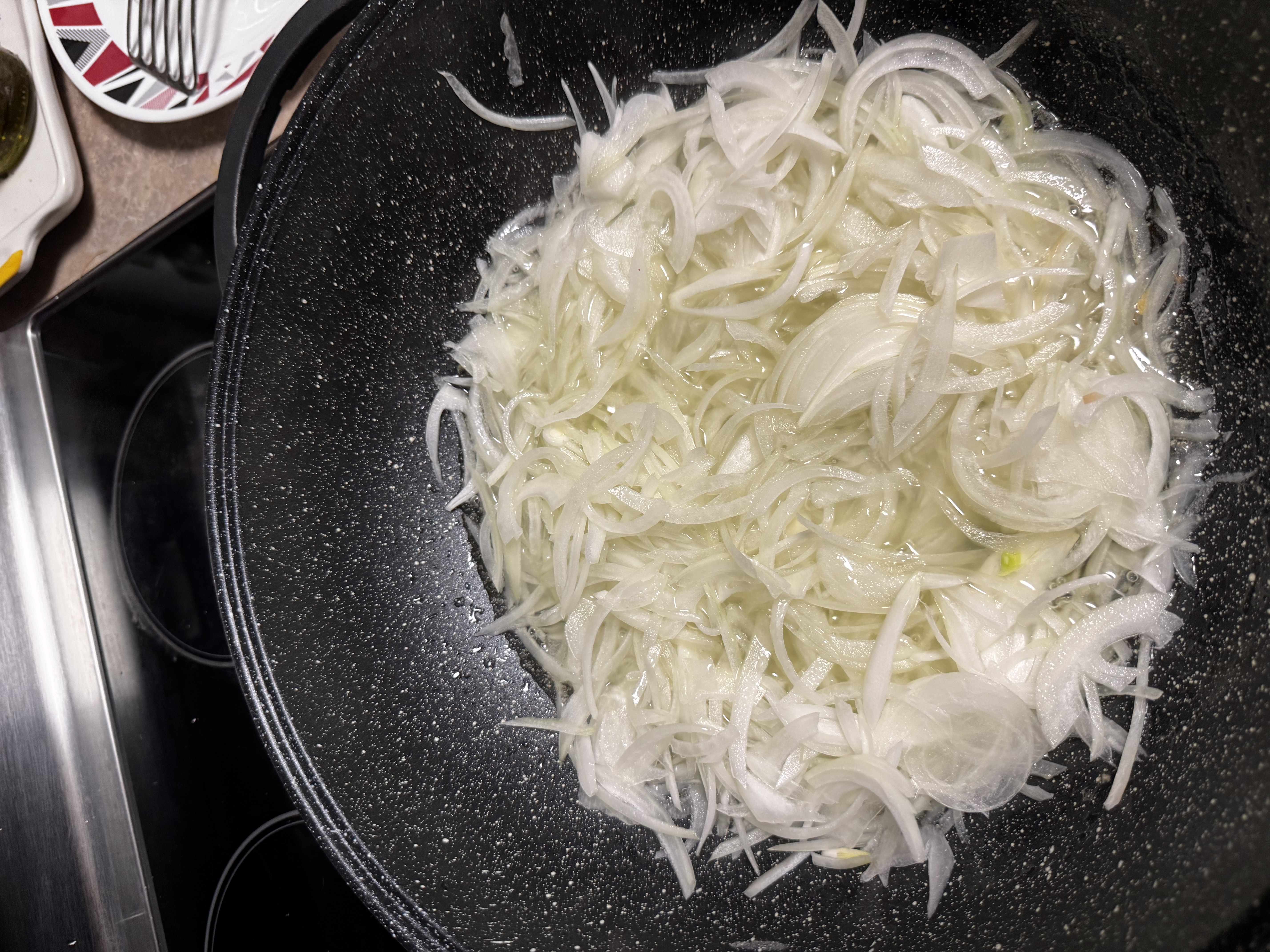 Onions frying in the wok at the start of a curry